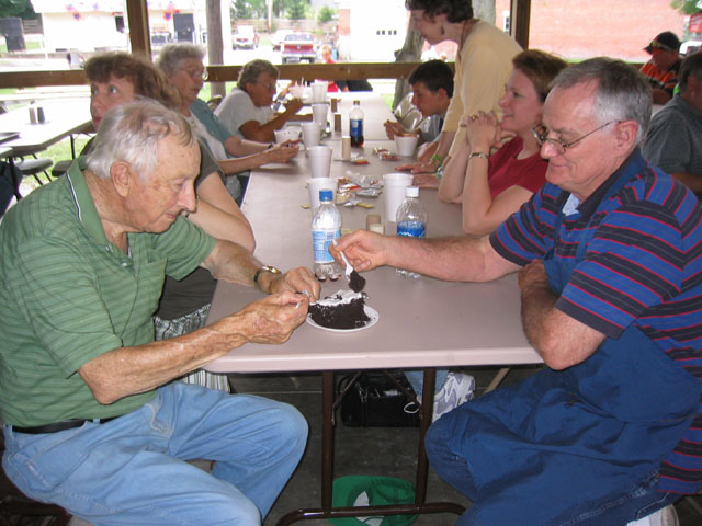 Clyde Ginder and Don Cates make fast work on a piece of chocolate cake.