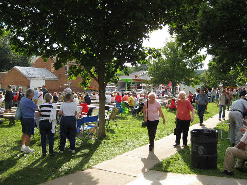 Afternoon sun warms the Village Park as the crowd gathers for evening entertainment.