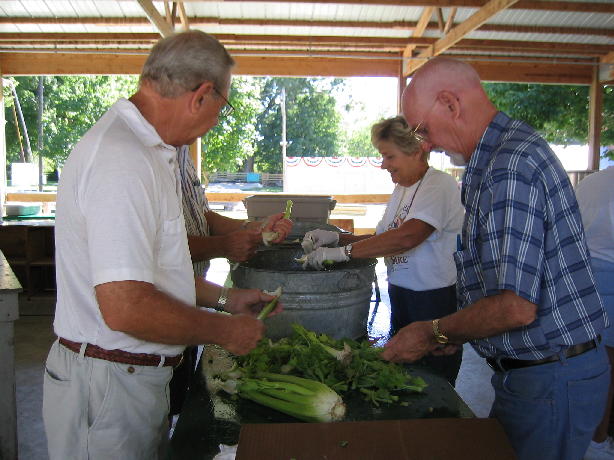 Ray Schnitker (left) and Joy Schnitker (far right) and Carol Lovekamp clean celery.