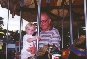 Waldron Paul steadies a grandchild on the carousel.
