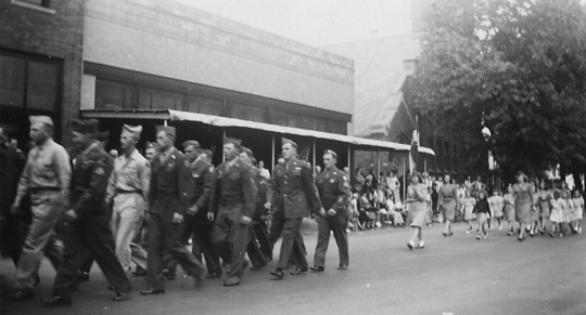 Veterans of World War II, some recently returned home, march through the village streets in 1949